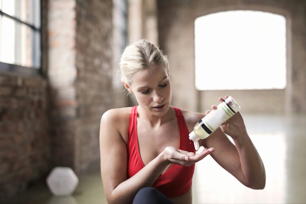 woman practicing self care with lotion