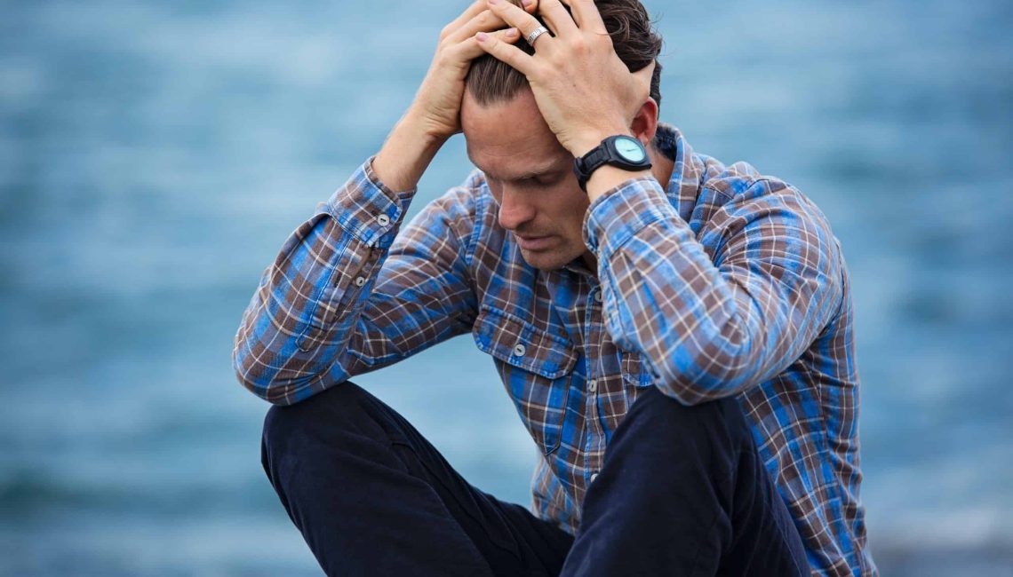 man holding his head sitting