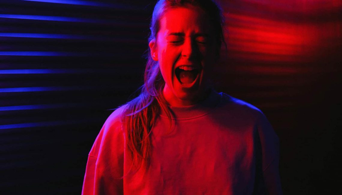 Young woman screaming from a PTSD nightmare